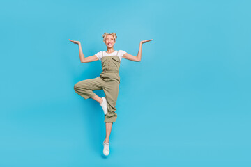 Canvas Print - Full length photo of cute blond lady jump hold promo wear t-shirt overall shoes isolated on blue background