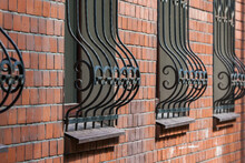 Windows In A Brick Wall With Figured Forged Metal Bars