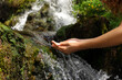 © Antonioguillem - Woman hands cupping catching water from waterfall