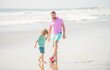 © Olena - little kid and dad running on beach in summer vacation with ball, football