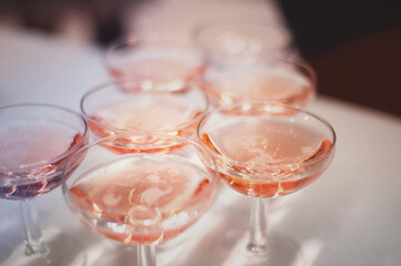 group of glasses with pink champagne on a high-class reception 