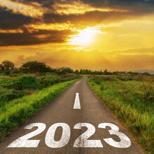 Empty Asphalt Road And New Year 2023 Concept. Driving On An Empty Road To Goals 2023 With Sunset.