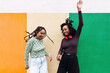 © VISTA by Westend61 - Happy friends dancing in front of multi colored wall