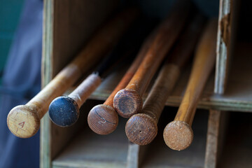 Sticker - Old wood baseball bats in a bat storage rack at a baseball park