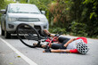 © VStudio - An Asian mountain biker was hit by a car on the road. A mountain biker was injured in a collision with a car on the road. Concept reduces accidents from using cars on the road. Selective focus.