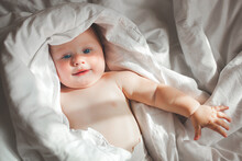 Cute Little Baby In The Blanket. Infant Awake. Adorable Child In The Bed.