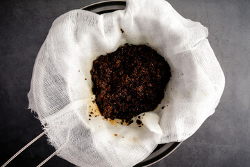 Wall Mural - Used Coffee Grounds in a Cheesecloth Lined Strainer: Coffee grounds leftover after straining cold brew