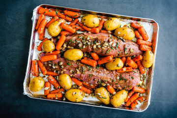Wall Mural - Marinated Pork Tenderloins with Vegetables on a Sheet Pan: Raw pork roast with baby potatoes and carrots on a baking pan