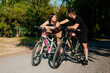 © stenkovlad - Young couple ride bicycles in the park.