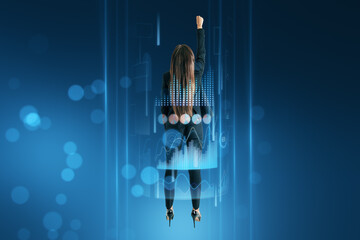 Canvas Print - Back view of businesswoman flying upward surrounded with business chart hologram on blurry blue background. Business boost up, success, future and start up concept.