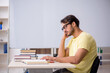 © Elnur - Young male student preparing for exams in the classroom