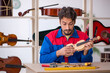 © Elnur - Young man repairing musical instruments at workshop