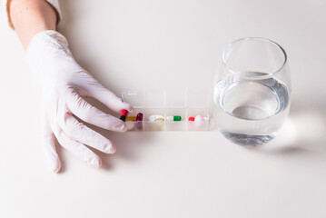 adult woman with gloves taking out a pill, medicinal, pandemic, health and wellness concept