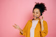 © Kateryna - Positive african american curly haired young woman with headset, customer support service, call center operator, expert, advises clients, standing on isolated pink background, smiling friendly
