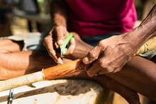 Hand Of An Indigenous Person Carving On The Surface Of The Blowpipe Or Sumpit. 