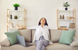 © Studio Romantic - Relaxed woman resting on soft comfy couch at home, breathing deeply, enjoying peace, quiet and comfort. Happy lady sitting eyes closed on sofa in cosy light livingroom with stylish shelves in own flat