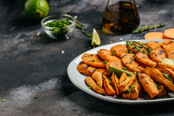 Wall Mural - Sweet potato fries with herbs on dark background. Long banner format. top view