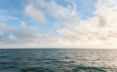 Wall Mural - Panoramic view from the Baltic sea shore after the storm. Clear sunset sky, reflections, still water surface texture. Nature, environment. Idyllic dreamlike seascape