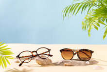 Sunglasses And Glasses Sale Concept. Trendy Sunglasses On A Beach With Green Palm Leaves. Trendy Fashion Summer Accessories. Copy Space For Text. Summer Sale. Optic Store Discount Offer Poster