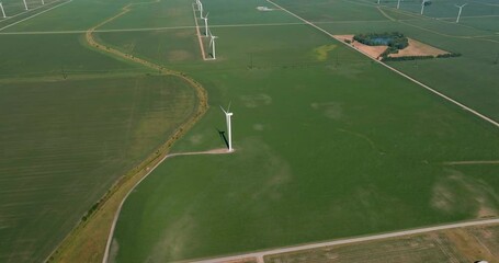 Wall Mural - Flying backwards above Wind Power Farm and green agriculture meadows . Aerial view, sunny clear sky