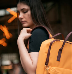 Wall Mural - Student girl with yellow backpack looking in to the camera through her shoulder