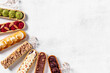 Sweet bakery eclairs with creamy decor, top view
