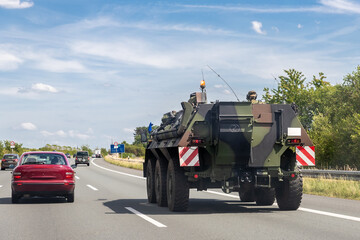 Wall Mural - German armoured personnel carrier Fuchs drives military convoy highway road. NATO troops moving reloceation for rapid reaction force reinforcement in eastern Europe