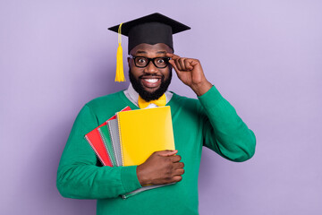 Wall Mural - Portrait of positive handsome guy hold book notebook touch eyeglasses isolated on purple color background