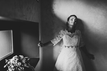 Wall Mural - Perfect fashion bride in luxury wedding dress. Bouquet of flowers with ribbon. Black and white photo.