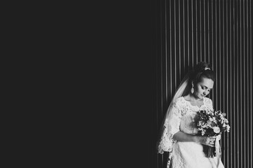 Wall Mural - Perfect fashion bride in luxury wedding dress. Bride holding hand bouquet of flowers with ribbon. Black and white photo.