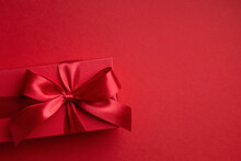 Red Gift Box With Red Bow On Red Background For Christmas Or Valentine's Day.