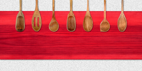 Topview of Set Cooking Wooden Spoons on Red Table Background