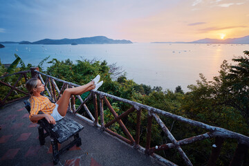 Wall Mural - Traveling by Thailand. Young woman enjoying wonderful sunset on Phuket island view point.