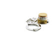 © William W. Potter - Business fraud and tax avoidance / evasion concept : Coin in a silver handcuff, depicts the use of illegal methods to modify financial situation or reports to lower or avoid paying tax. White isolated