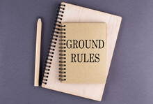 Word GROUND RULES On Notebook With Pencil On The Grey Background