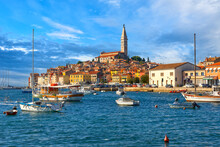 Beautiful View Of The Harbor With Boats, Yachts And A Old Town Buildings, Campanile Of Saint Euphemia Church Of Rovinj City Against A Blue Sky In Sunny Day. Rovinj, Istria, Croatia