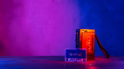 Vintage cassette tape player in neon light. 80s - 90s advertisement style. Disco party nostalgy concept