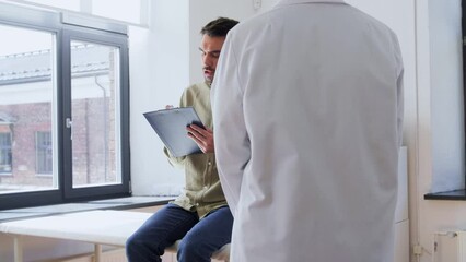 Poster - medicine, healthcare and people concept - male patient with clipboard signing papers and giving it to female doctor at hospital