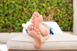 the boy's bare feet on the chaise longue. resting boy in the sun. The concept of relaxation.
