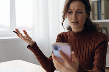 Financial troubles concept. Irritated angry evil curly pretty woman don't know what to do in life for making better her money problems and business failure bankruptcy sitting at home at table