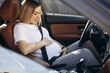 © Petro - Pregnnat woman sitting in car preparing to give a birth