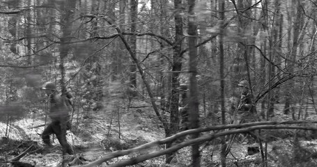 Wall Mural - Men Dressed As American Soldiers Of USA Infantry Of World War II Marching Walking Along Forest Road In Autumn Day. Group of Soldiers Marching In Forest. Black and white colors.