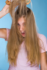 Wall Mural - Blond young woman brushing her hair