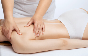 Masseur makes a relaxing massage on the neck, shoulders, back and collarbones of a young beautiful woman in a spa. Treatment for back pain.