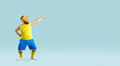 Funny plump man in sportswear dancing isolated on blue copy space background. Happy cheerful fat guy in yellow top and blue shorts pointing to copyspace on right side. Sport, fitness workout concept