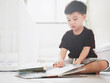 © olando - little boy with a book sitting on the floor