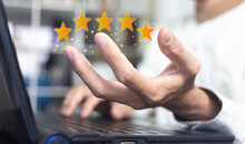 Hand Of Businessman Holding Five Stars Icon And Work With Laptop At Workplace Or Office, Best Quality Products Business Concept