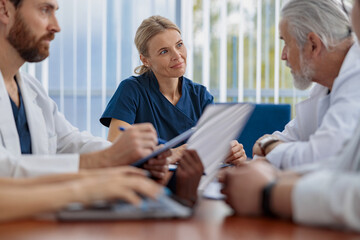 Sticker - Group of doctors sitting at meeting table in conference room during medical seminar