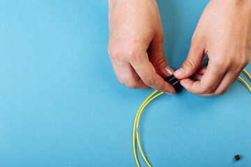 Wall Mural - Hands prepare to tune a variable optic attenuator with a screwdriver. Blue background