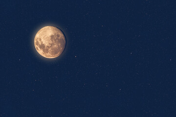 Wall Mural - full moon at dusk glowing against blue starry sky dark background